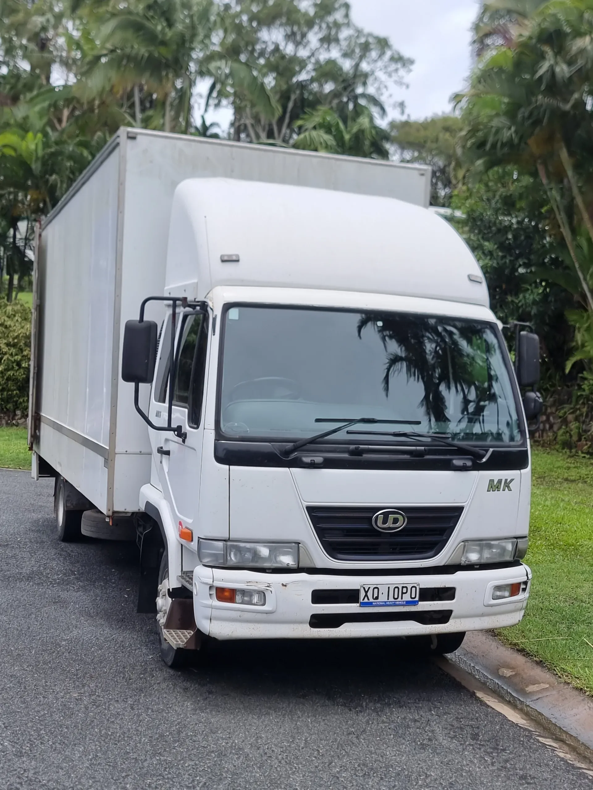 White box truck parked beside a grassy verge