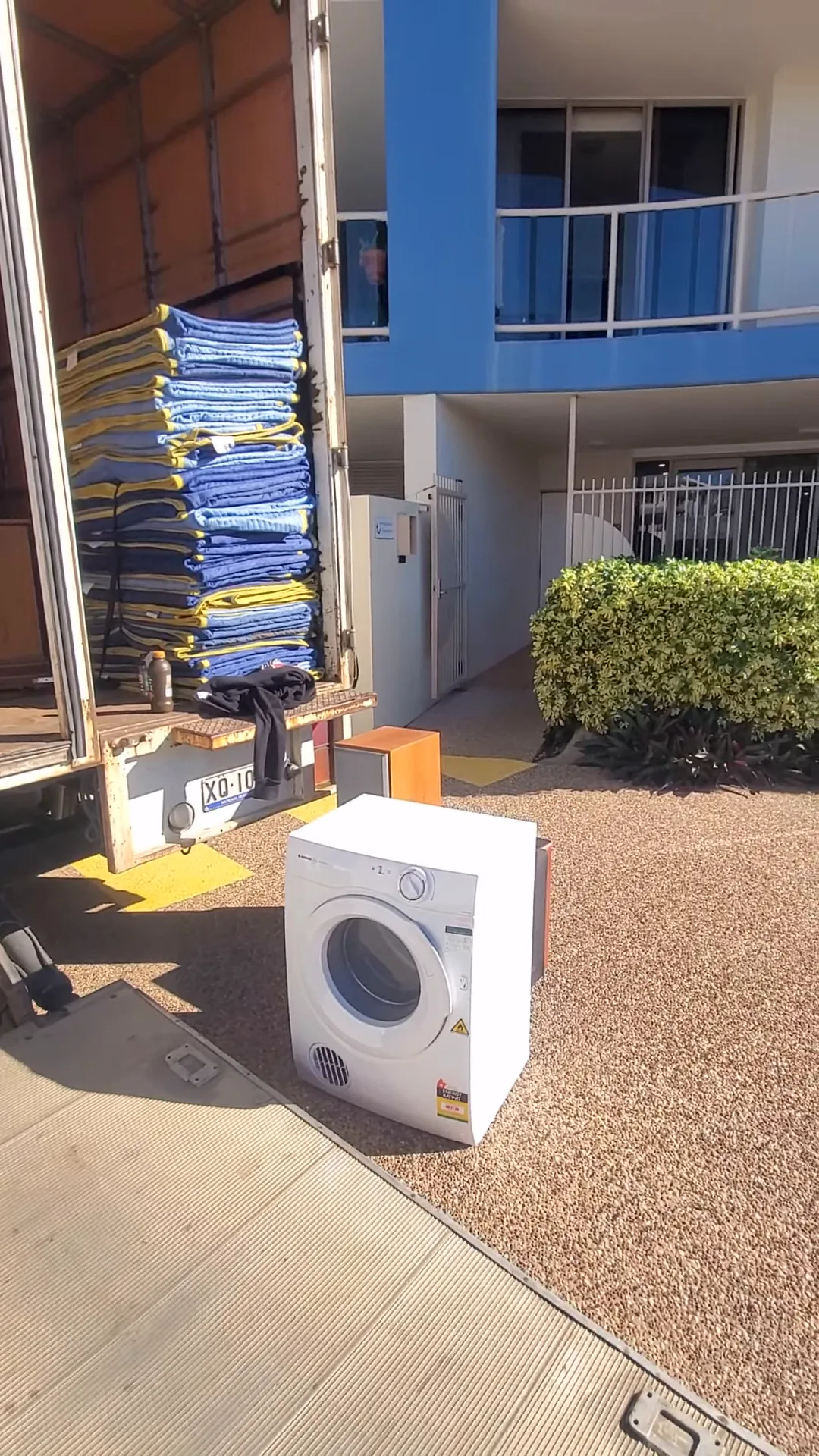 Box truck unloading an appliance at a residential property