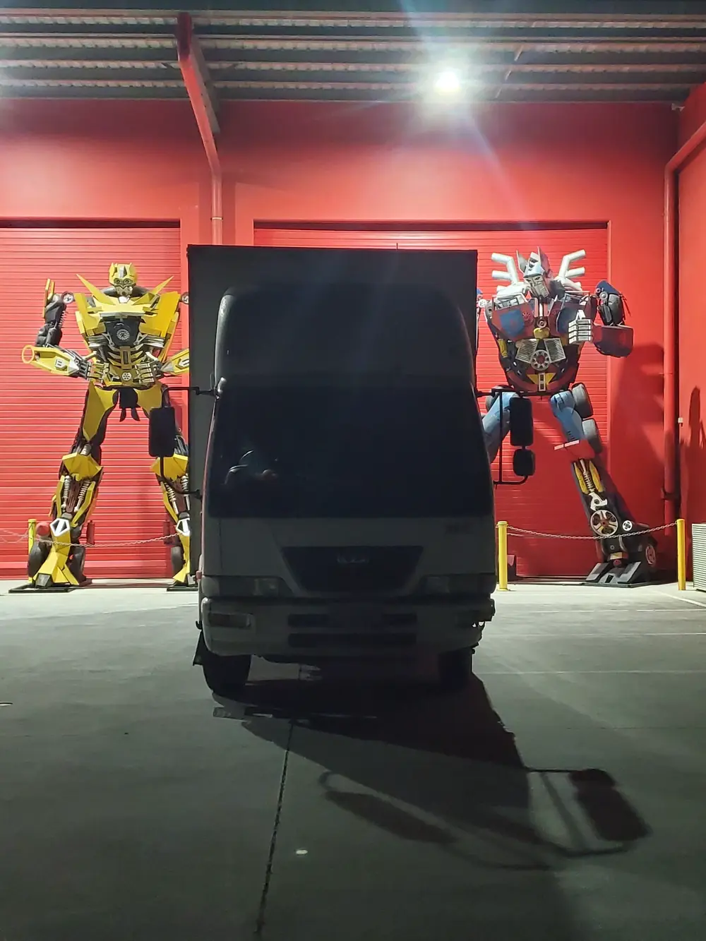 Black van parked in a loading area beside large display figures