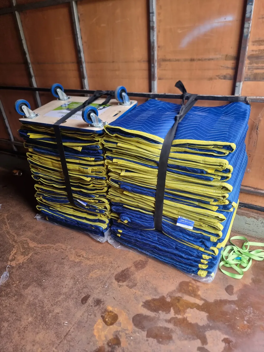 Stacked furniture blankets and trolleys strapped inside a freight truck