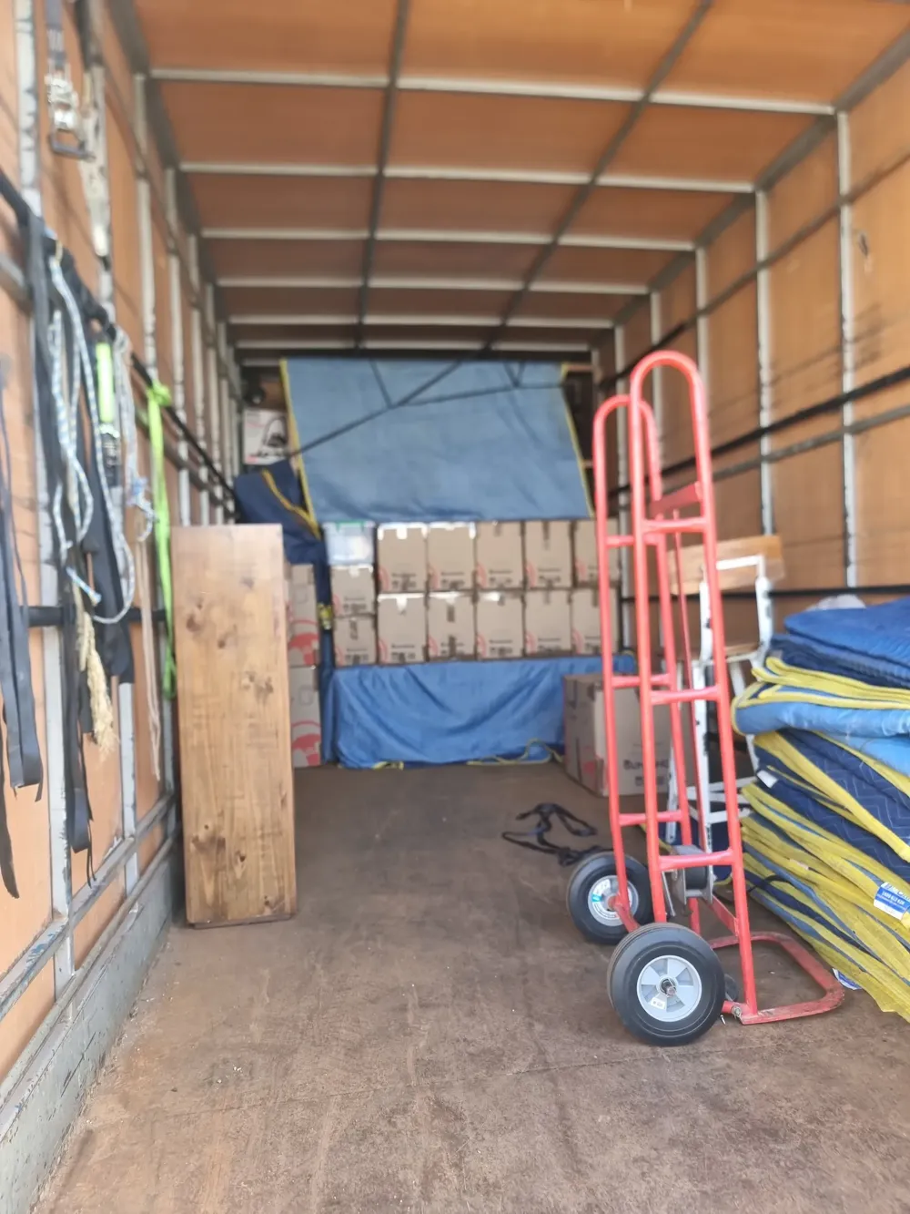 Boxes, trolleys and wrapped furniture secured inside a box truck